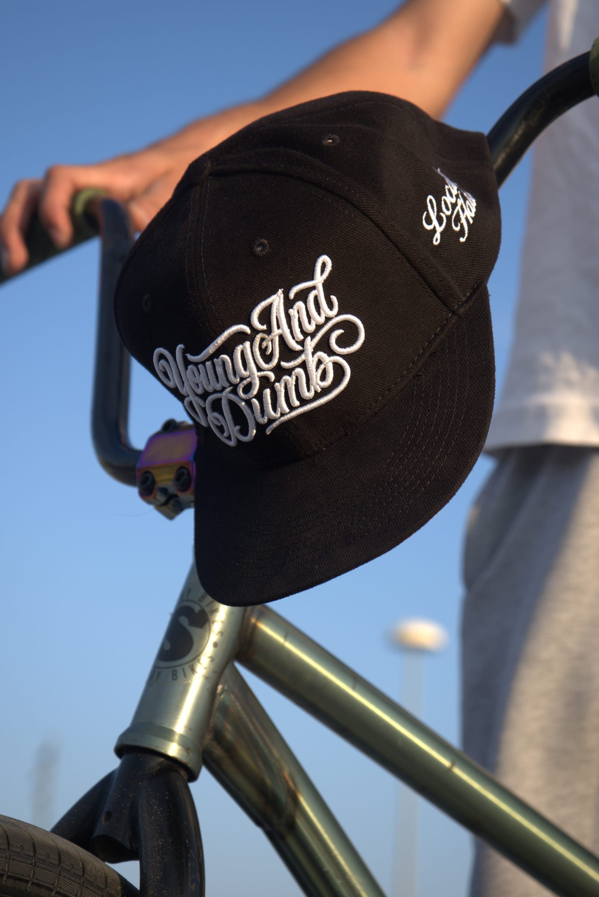BMX gidonuna asılı siyah Young And Dumb şapka